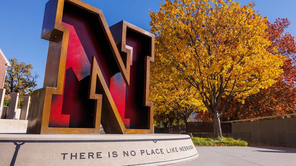 N Sculpture outside Alumni center with fall foliage in the background